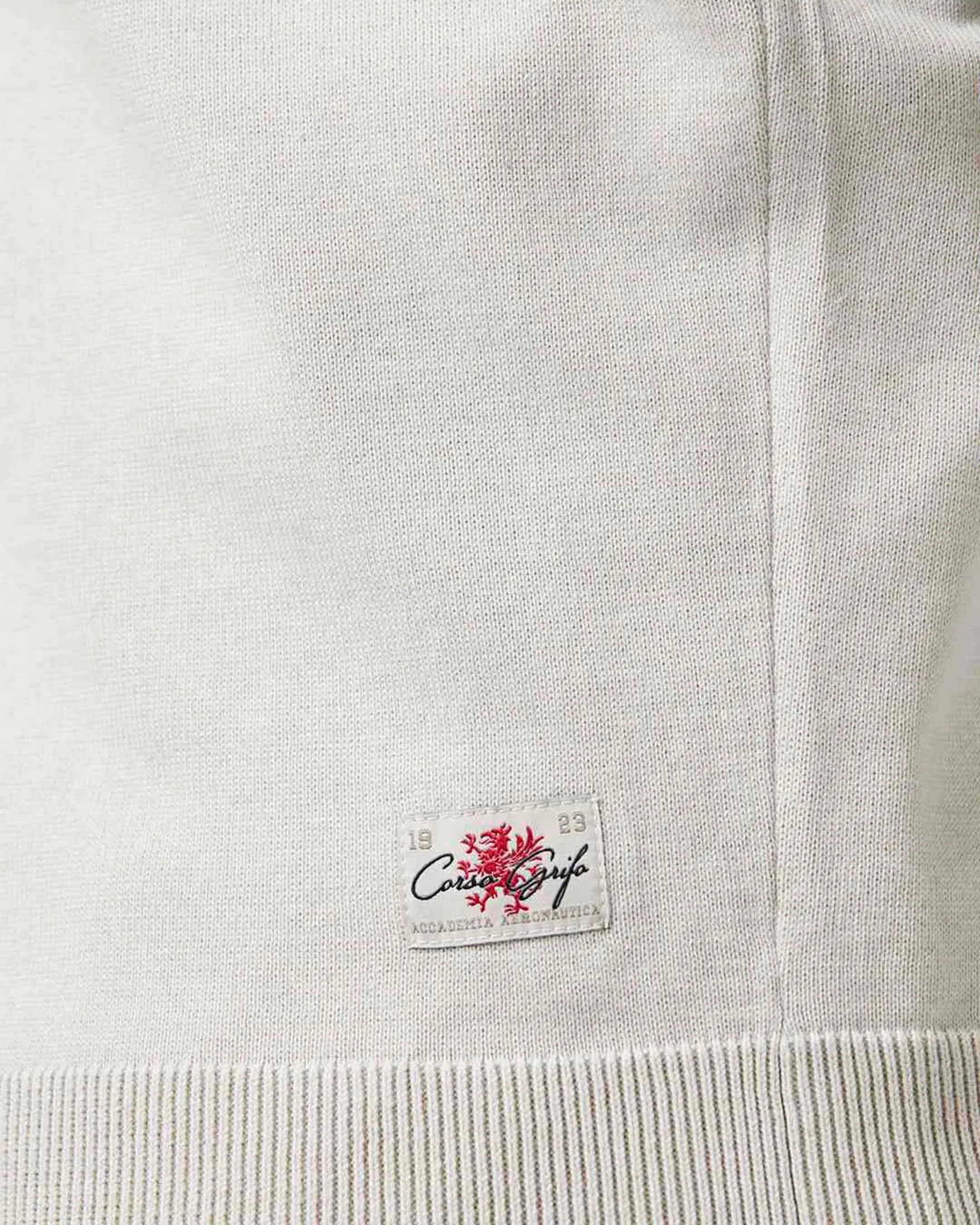 Maglia color ghiaccio in puro cotone con chiusura a mezza zip e aquila turrita ricamata sul petto